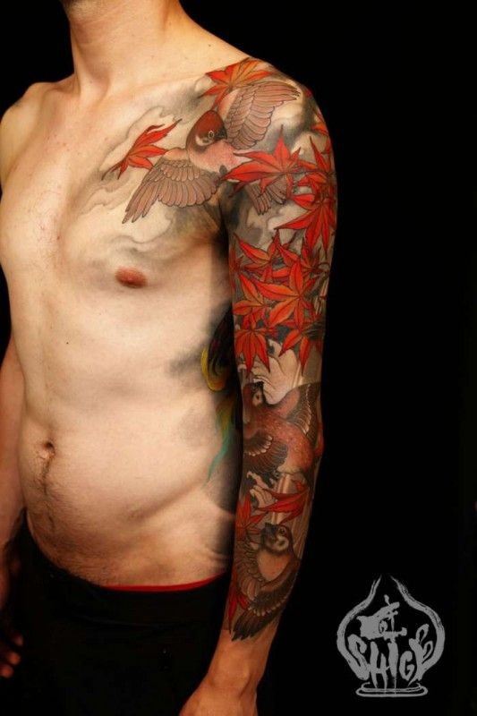 Tatuaje en el brazo, bandada de aves y hojas otoñales