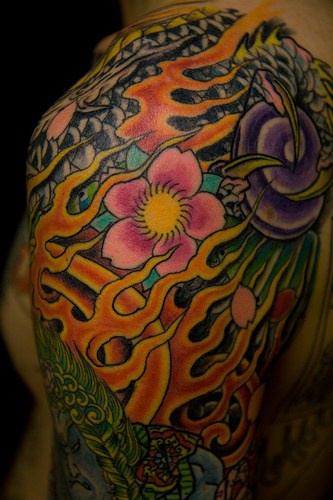 stile asiatico il fiame e i  fiori tatuaggio colorato