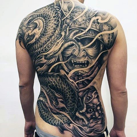 Asian style massive black and white whole back tattoo of dragon with samurai mask and creepy man portrait