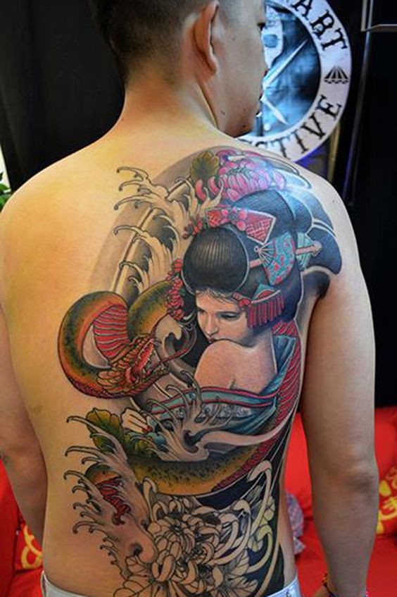 Tatuaje en la espalda,
geisha linda con serpiente enorme, estilo asiático