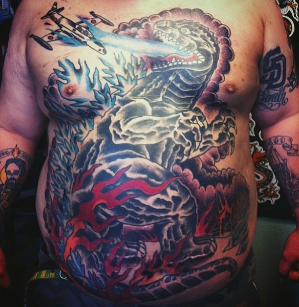Tatuaje en el pecho y vientre, Godzilla enorme en llamas con avión diminuta