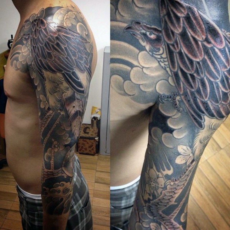 Asian traditional style colored fling eagle tattoo on sleeve with feather
