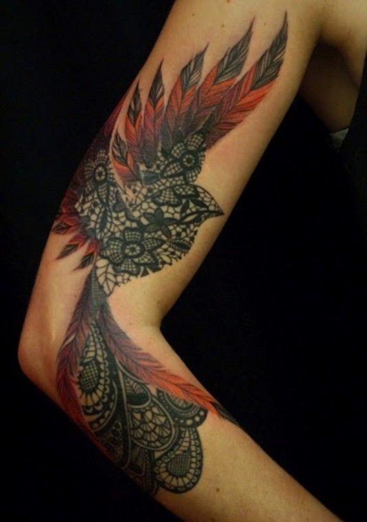 Tatuaggio colorato sul braccio l&quotuccello con i disegni