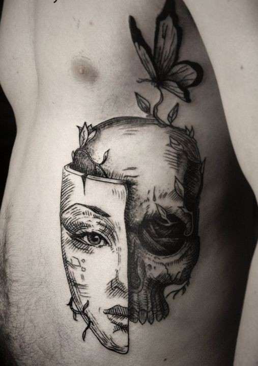 Tatuaje en las costillas,
cráneo con parte de máscara