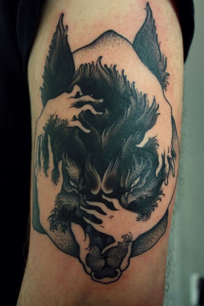 Awesome black wolf with white hands of man tattoo on shoulder
