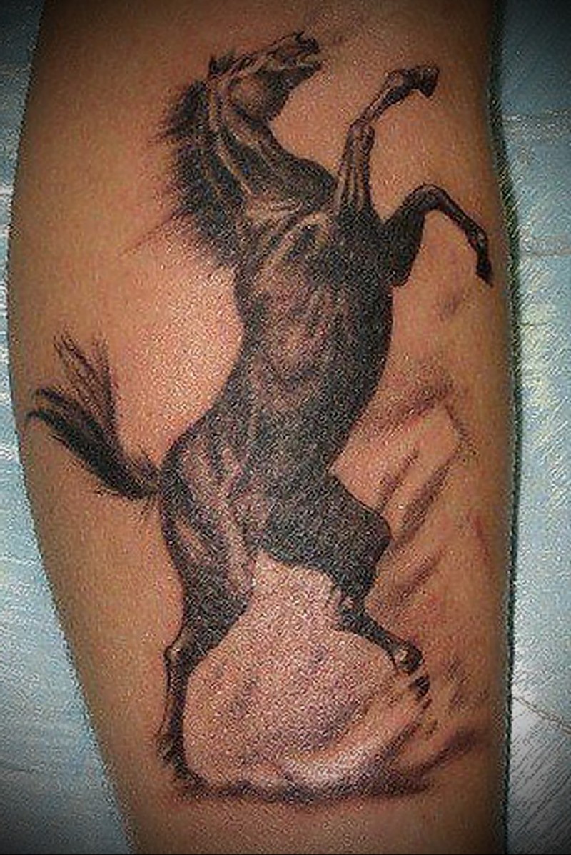 Tatuaje en la pierna, caballo negro  en sus patas traseras