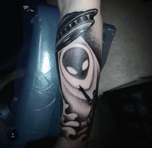Awesome designed little black alien ship with human tattoo on arm