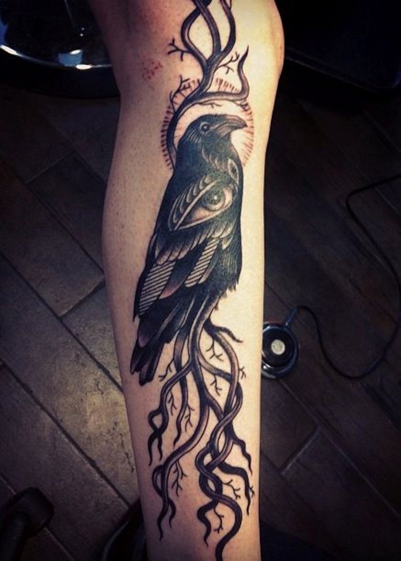 Awesome detailed black ink crow stylized with mystic eye tattoo on leg