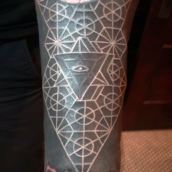 Tatuaje en el antebrazo, ornamento geométrico blanco en el fondo negro