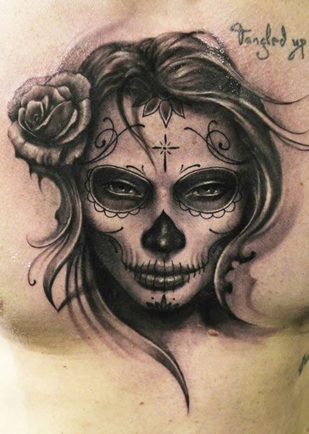 Tatuaje en el pecho, 
cara de santa muerte, color gris