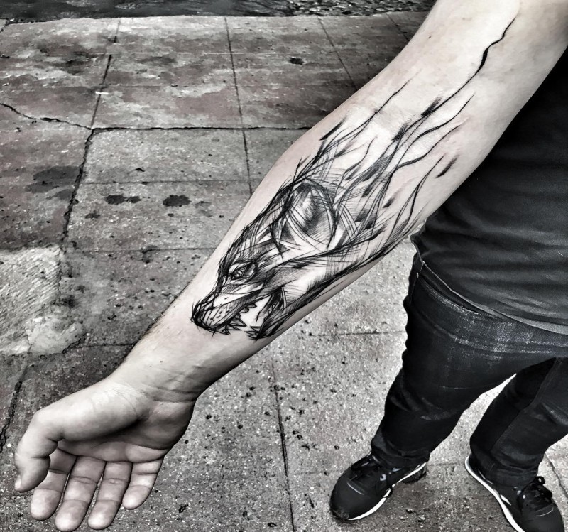 Tatuagem de antebraço de tinta preta impressionante de cabeça de lobo por Inez Janiak