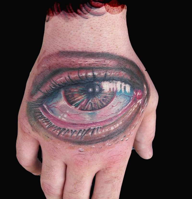 Awesome very detailed colored sad eye tattoo on hand