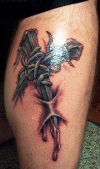 Barbed wire with cross tattoo on leg