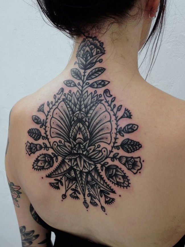 Tatuaje en la espalda alta, idea interesante de 
flores diferentes