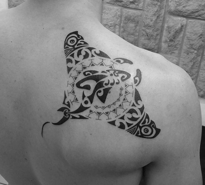 Beautiful big black ink upper back tattoo of ray stylized with tribal paintings