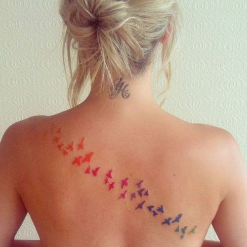 Tatuaggio colorato sulla schiena lo stormo degli uccelli