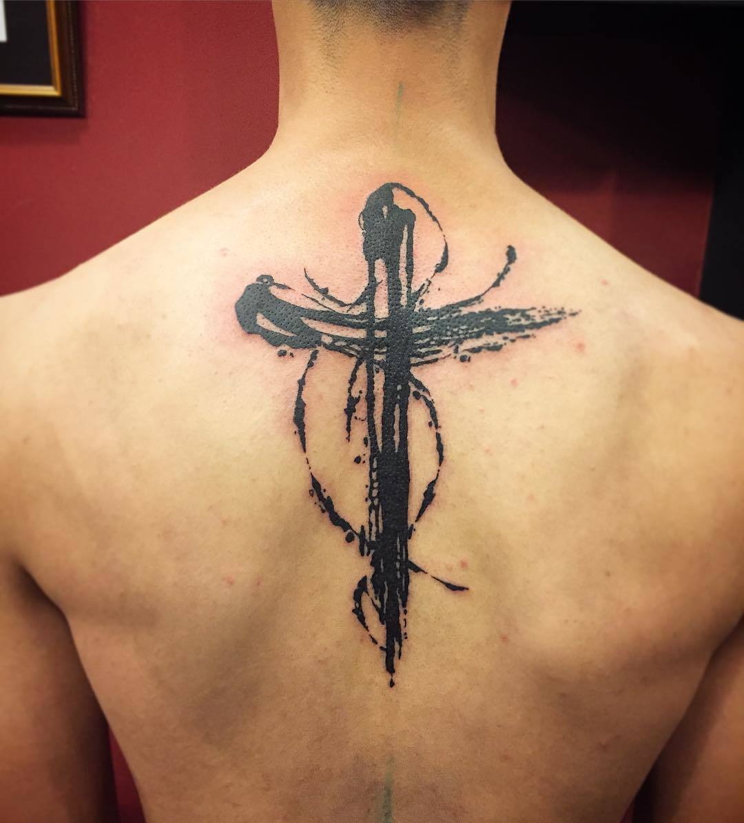 Beautiful black cross tattoo on back