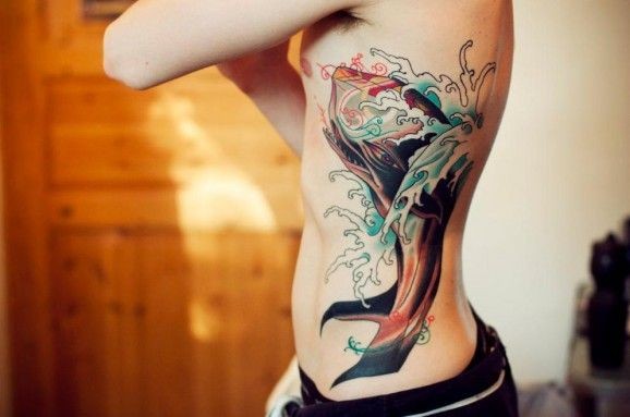 Tatuaggio colorato sul fianco la balena tra le onde by Jimmy Duvall