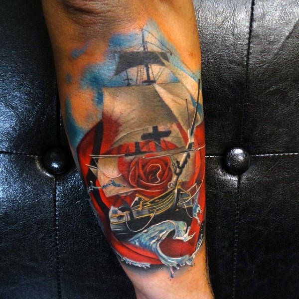 Beautiful colored little ship in waves and flower tattoo on arm
