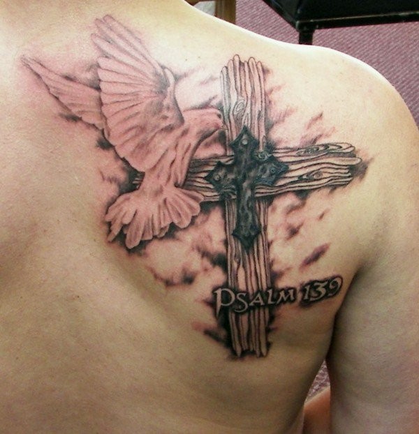 Beautiful cross and pigeon swooping tattoo on shoulder blade
