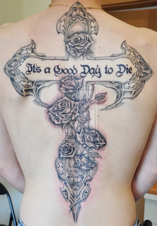 Tatuaje en la espalda,
cruz decorado con flores y inscripción