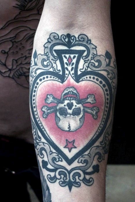 Tatuaje en el antebrazo, pica única con ornamento y dibujo de calavera