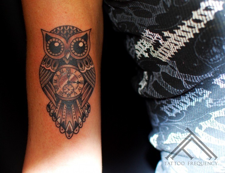 Beautiful detailed black and white owl shaped clock tattoo on arm