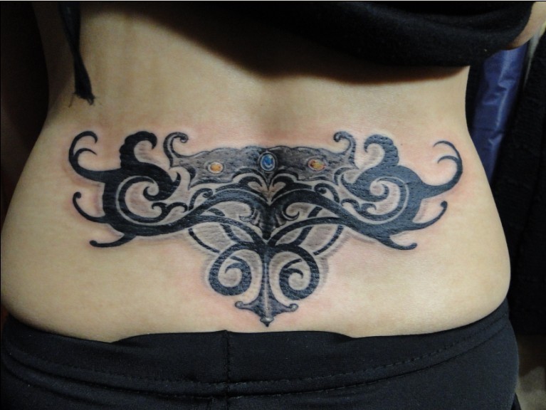 Beautiful dramatic tribal tattoo on lower back