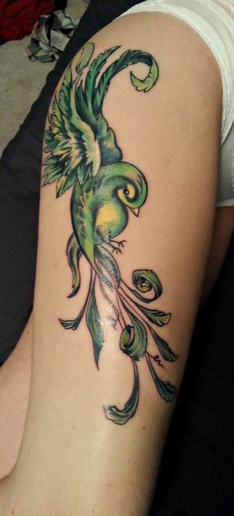 Beautiful green bird tattoo on thigh for women