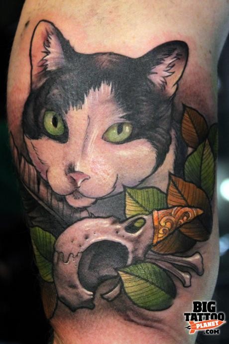 Beautiful looking colored arm tattoo of cat with bird skull and leaves