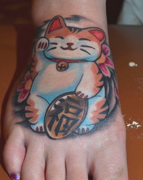 Beautiful looking colored foot tattoo of cute maneki neko japanese lucky cat with small tablet