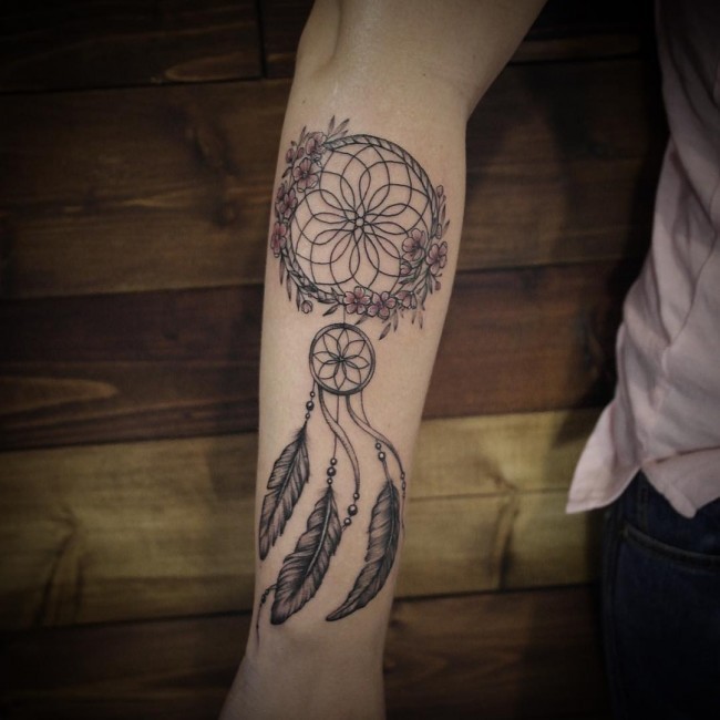 Schön aussehendes farbiges Unterarm Tattoo von Traumfänger mit Feder