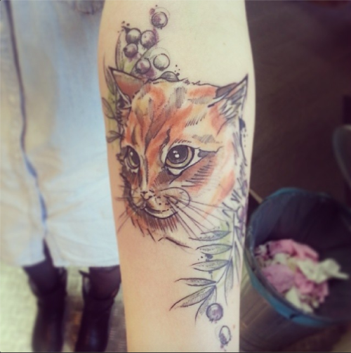 Beautiful looking colored forearm tattoo of cat face with berries