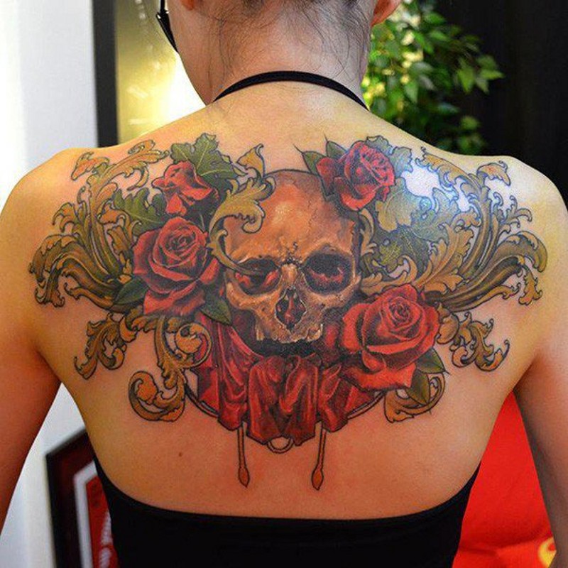 Schönes buntes Tattoo am oberen Rücken mit menschlichem Schädel und Blumen