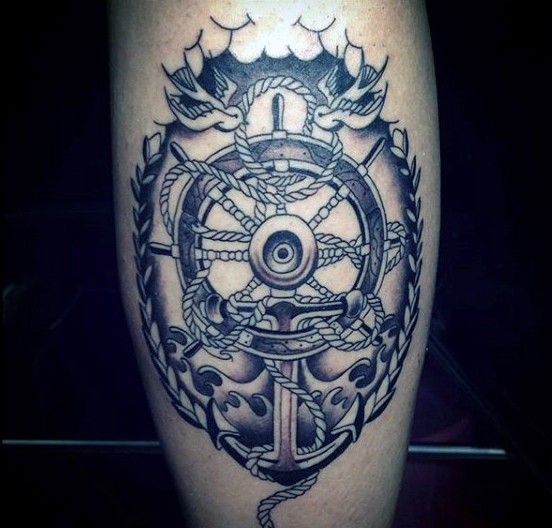Beautiful nautical style black and white ship steering wheel with anchor tattoo on thigh