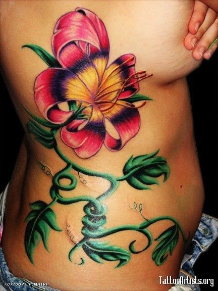 Beautiful painted big multicolored flower with leaves tattoo on waist