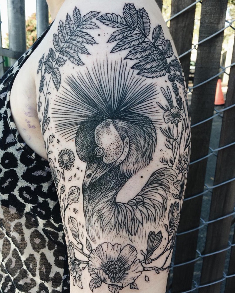 Beautiful painted black ink peacock tattoo on shoulder with wildflowers