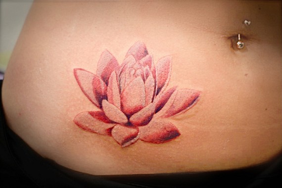 Beautiful pink lotus flower tattoo on stomach