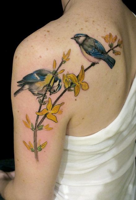 Tatuaje en el hombro, paruses en la rama con flores amarillos