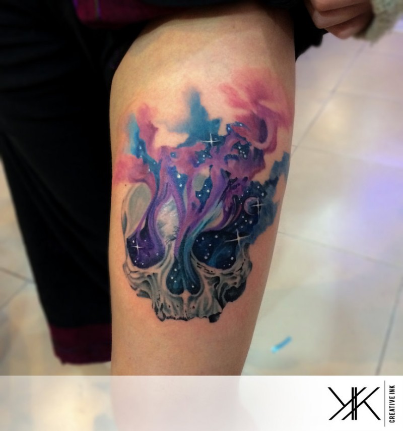 Beautiful space themed colorful on thigh tattoo of skull in colorful fog