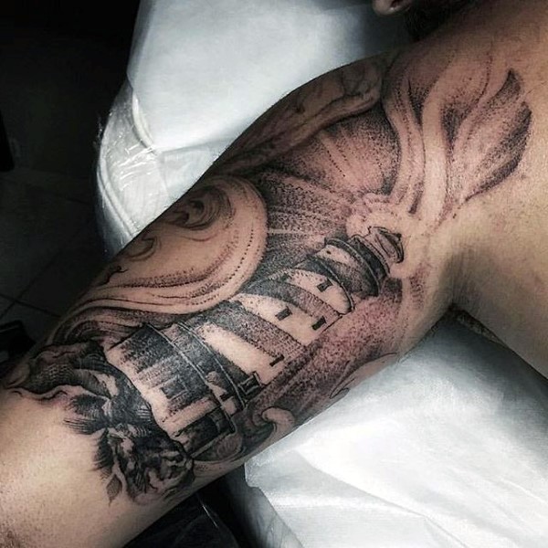 Beautiful stippling style lighthouse tattoo on upper arm