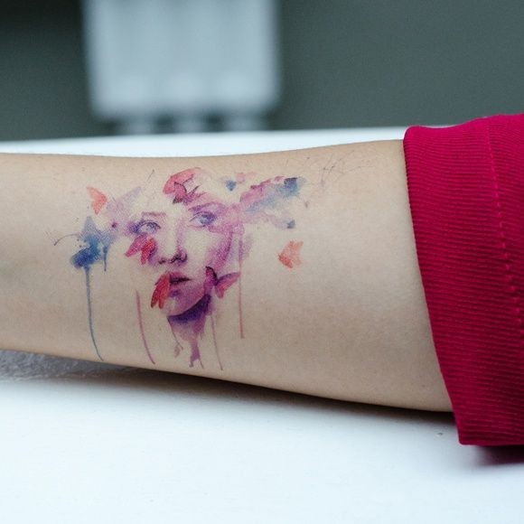 Beautiful watercolor portrait of girl and butterfly forearm tattoo