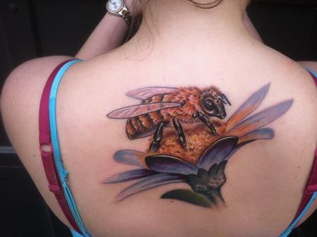 Bee sitting on flower tattoo on back