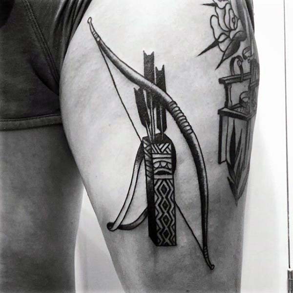 Big antic like archer weapons tattoo on thigh