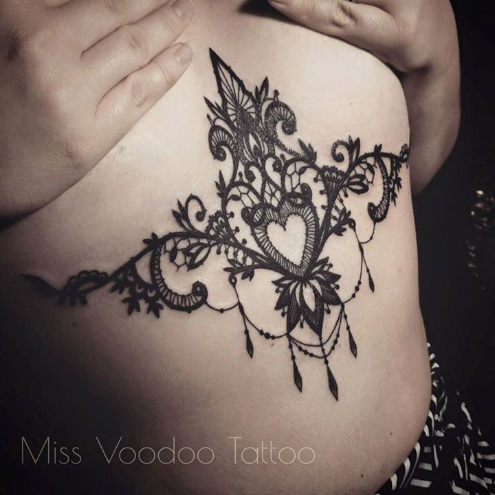 Tatuaggio di grande pancia con ornamenti floreali con cuore di Caro Voodoo