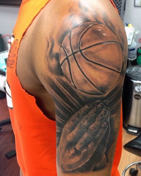 Big black and gray style shoulder tattoo of basketball and praying hands