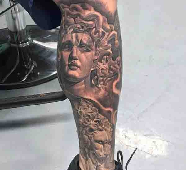 Tatuaje la cabeza de Medusa antigua con la figura del león en la pierna