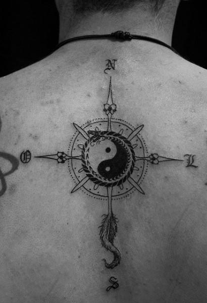 Big black and white back tattoo of compass stylized with Yin Yang symbol