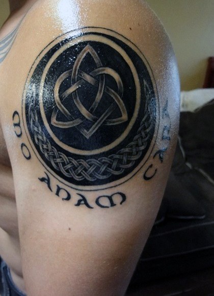 Großes schwarzes und weißes keltisches Symbol Tattoo an der Schulter mit Schriftzug