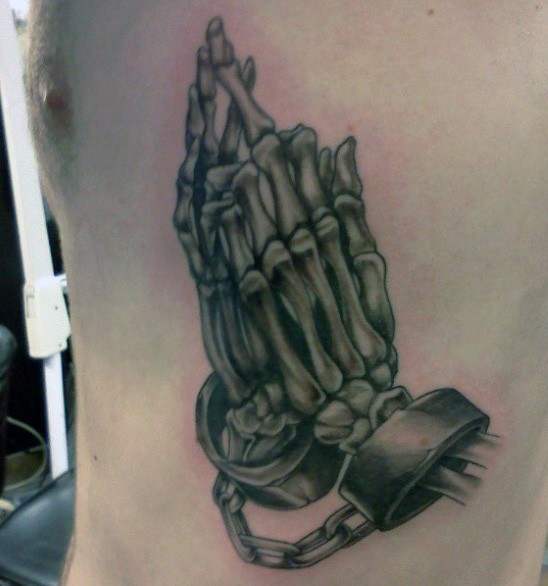 Big black and white chained skeleton hands tattoo on side